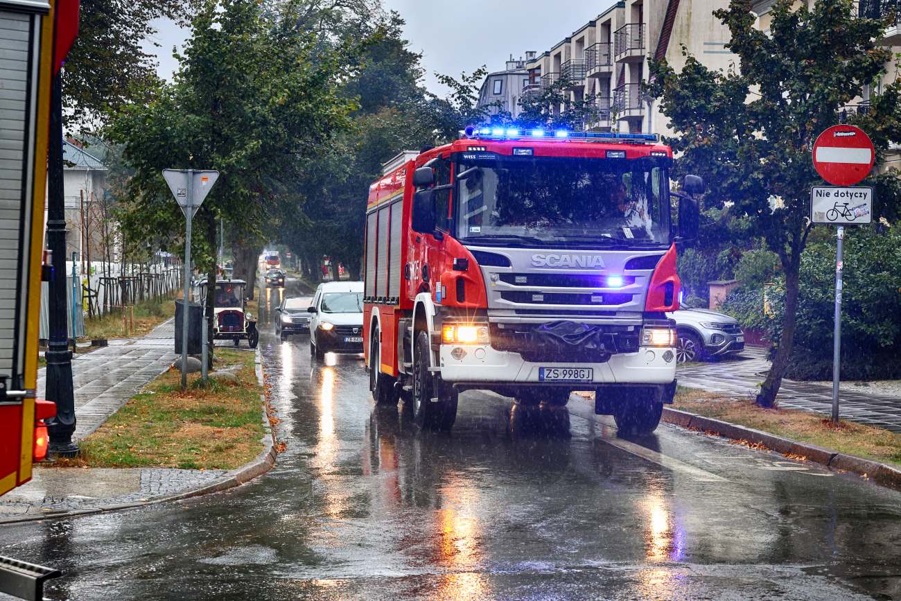Samochód straży pożarnej w deszczy na sygnałach.